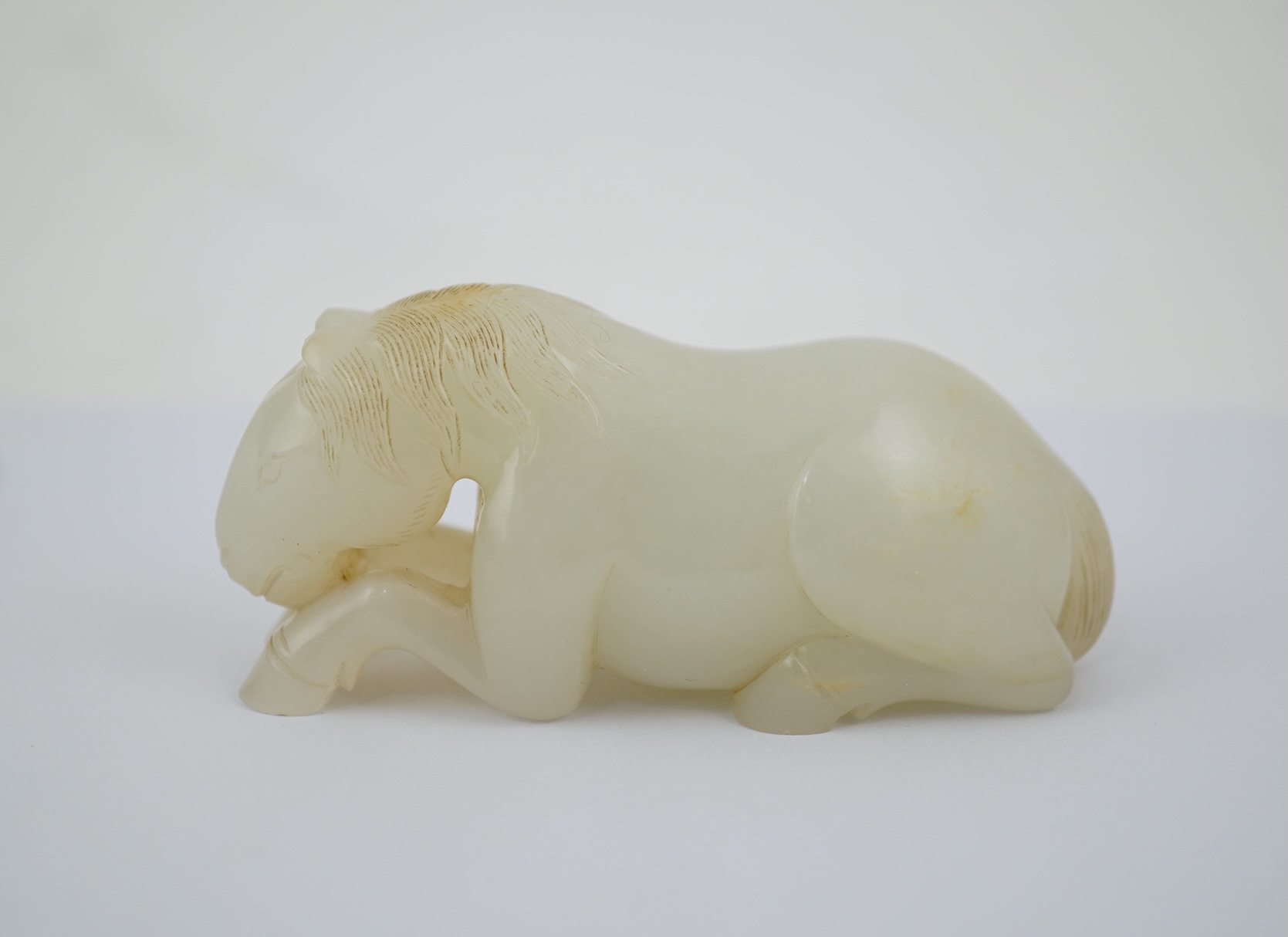 A Chinese white jade figure of a recumbent horse